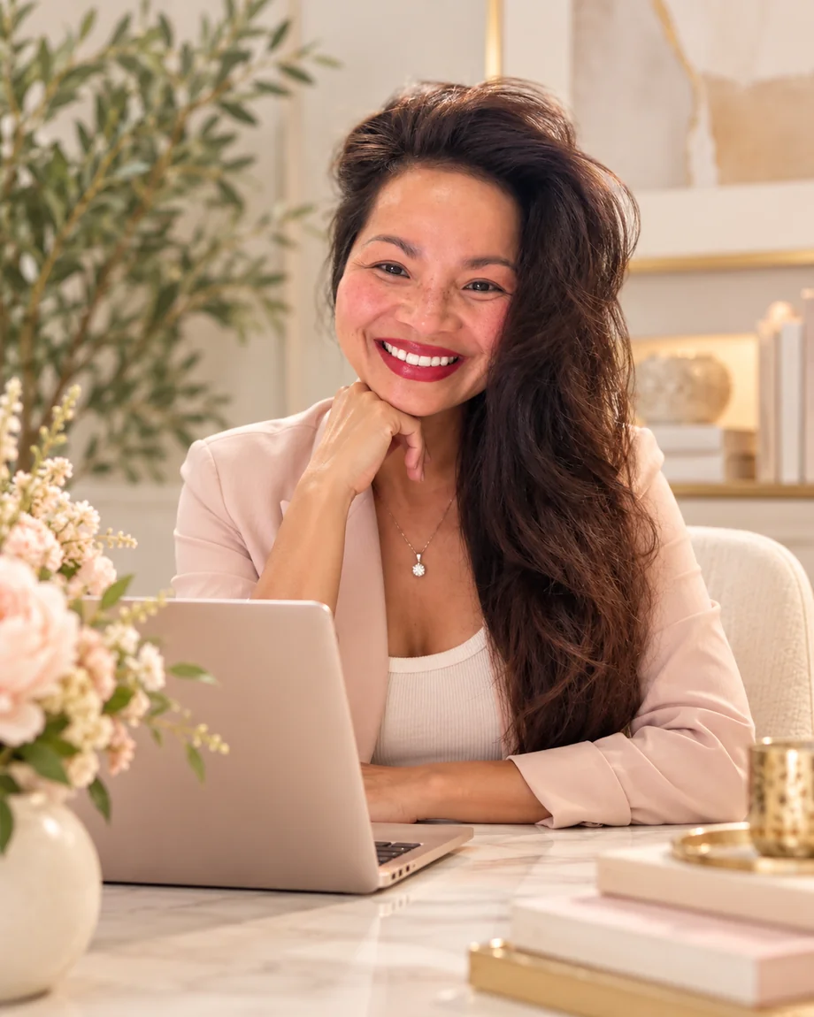 Melinda Bui, founder of BUI Creative Labs, in a blush blazer, working at her desk